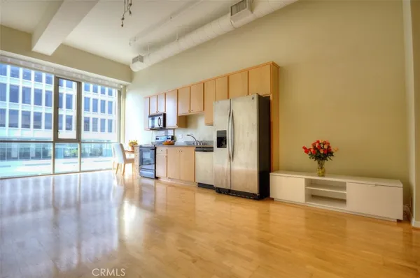 a kitchen with stainless steel appliances a refrigerator and a view of living room