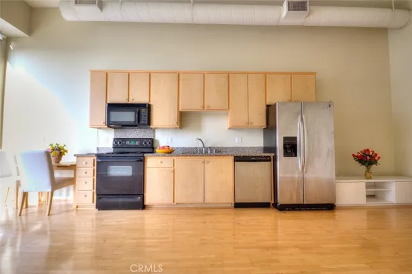 a kitchen with granite countertop a refrigerator and a stove top oven