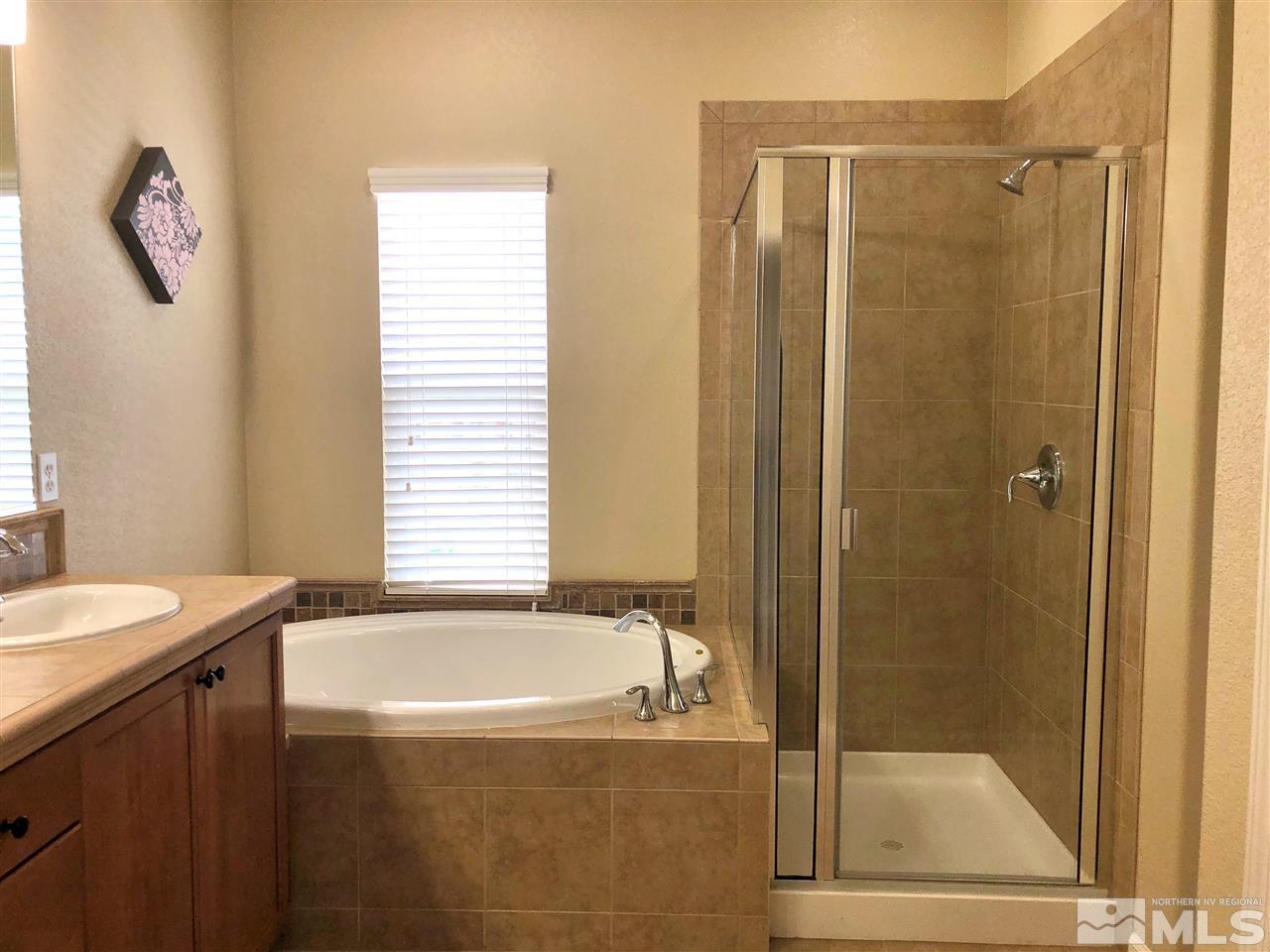 230 Gramercy Lane Reno, NV 89509 - Photo 12 of 20 a bathroom with a granite countertop sink a mirror and a bathtub