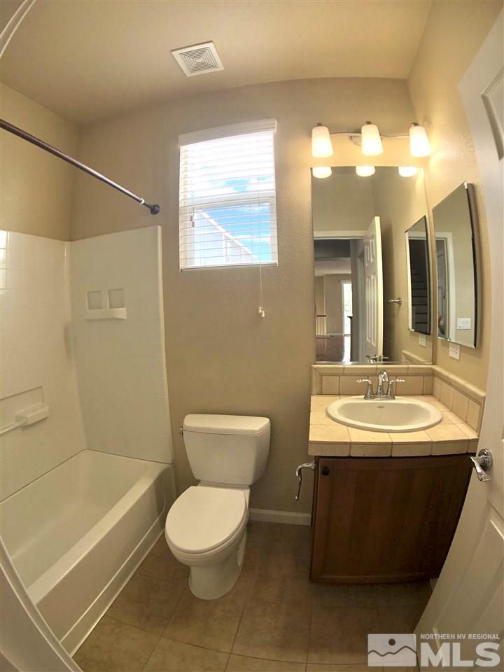 230 Gramercy Lane Reno, NV 89509 - Photo 15 of 20 a bathroom with a toilet a sink a mirror a bathtub and shower
