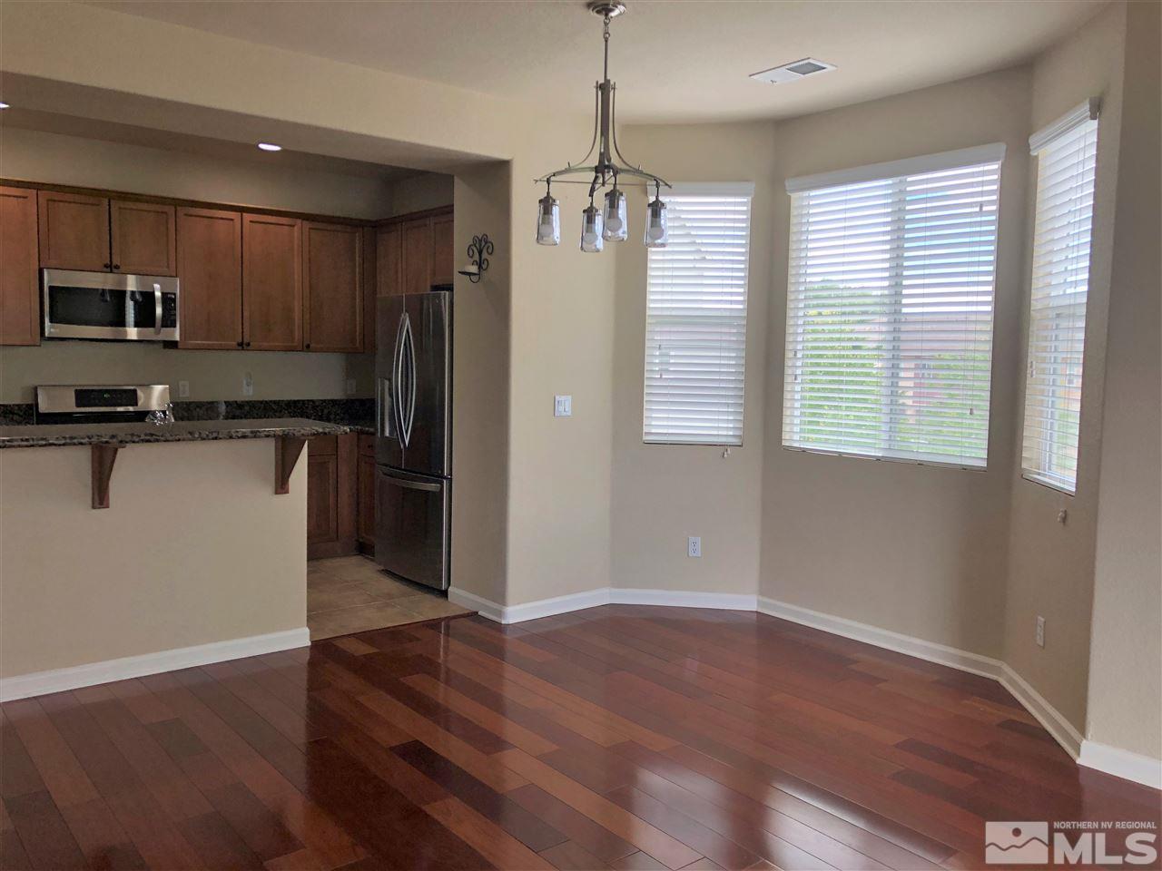 230 Gramercy Lane Reno, NV 89509 - Photo 8 of 20 a kitchen with stainless steel appliances granite countertop a refrigerator a sink dishwasher a stove and white countertops with wooden floor