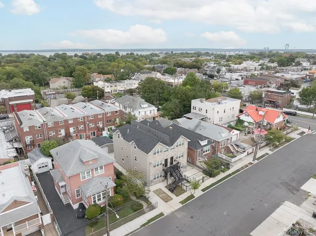 an aerial view of residential houses with outdoor space and trees