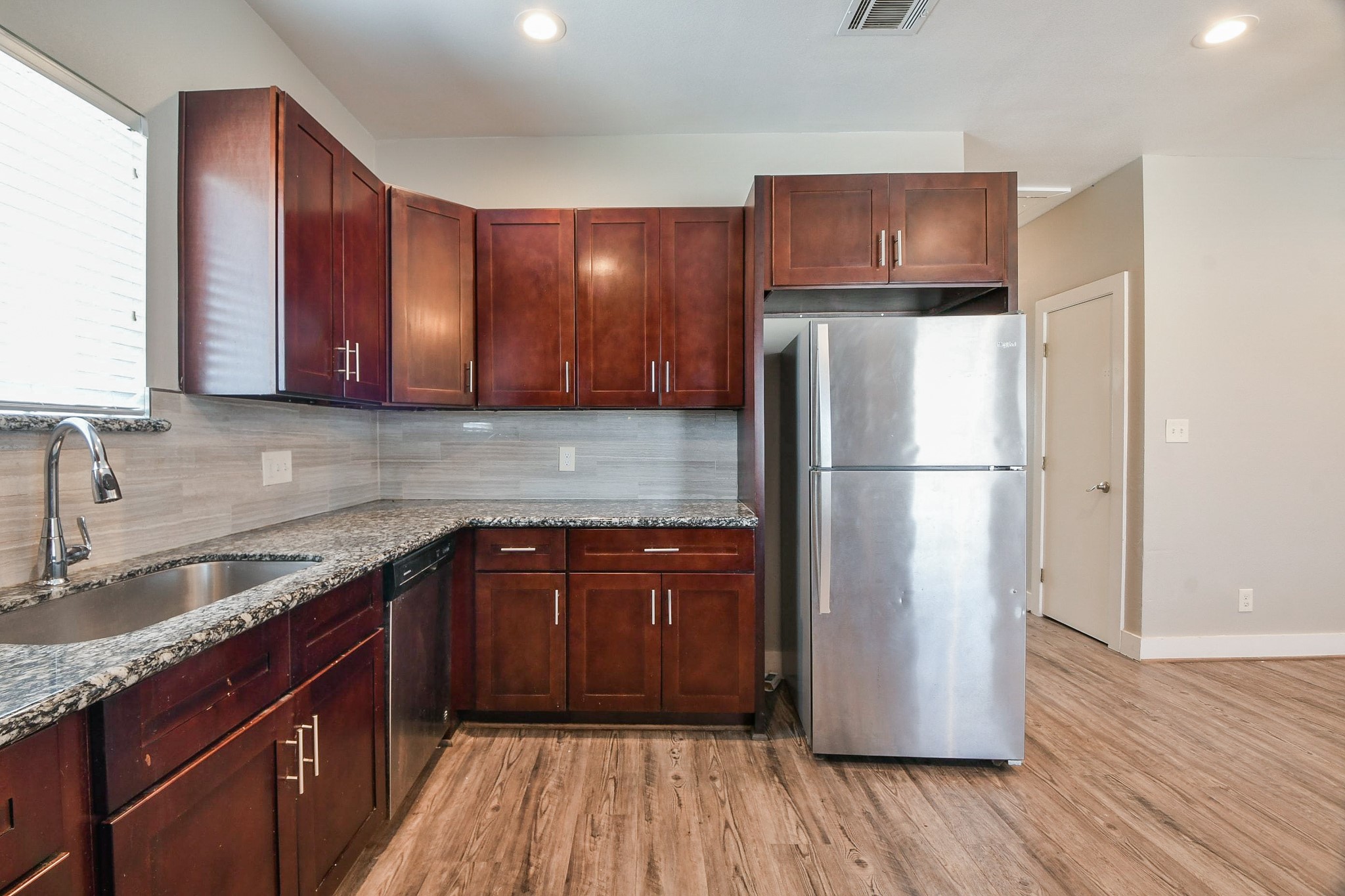 3249 Dixie Drive, Unit B Houston, TX 77021 - Photo 7 of 25 a kitchen with a refrigerator sink and wooden cabinets
