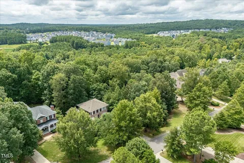 an aerial view of a houses with yard and outdoor seating