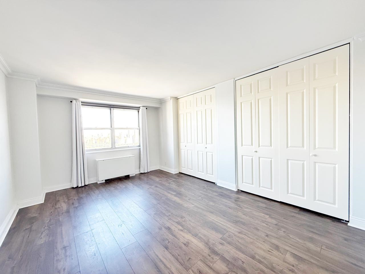 6600 Boulevard East, Unit 22B West New York, NJ 07093 - Photo 3 of 20 an empty room with wooden floor and windows