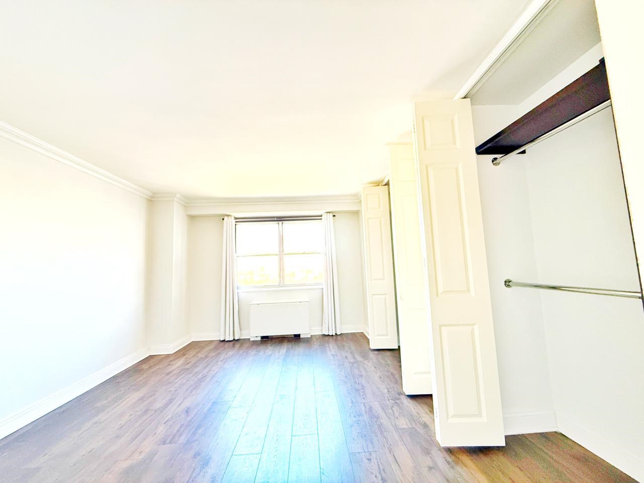 6600 Boulevard East, Unit 22B West New York, NJ 07093 - Photo 4 of 20 an empty room with wooden floor and a window