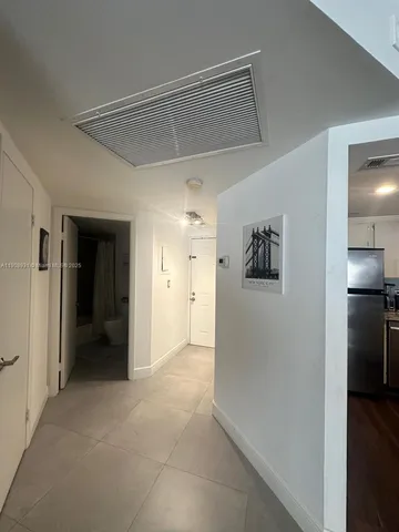 a view of a hallway with closet and wooden floor