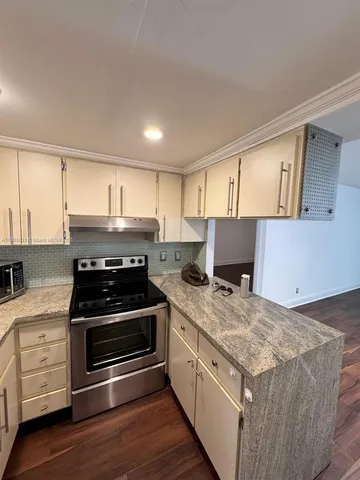 a kitchen with granite countertop a stove and a sink