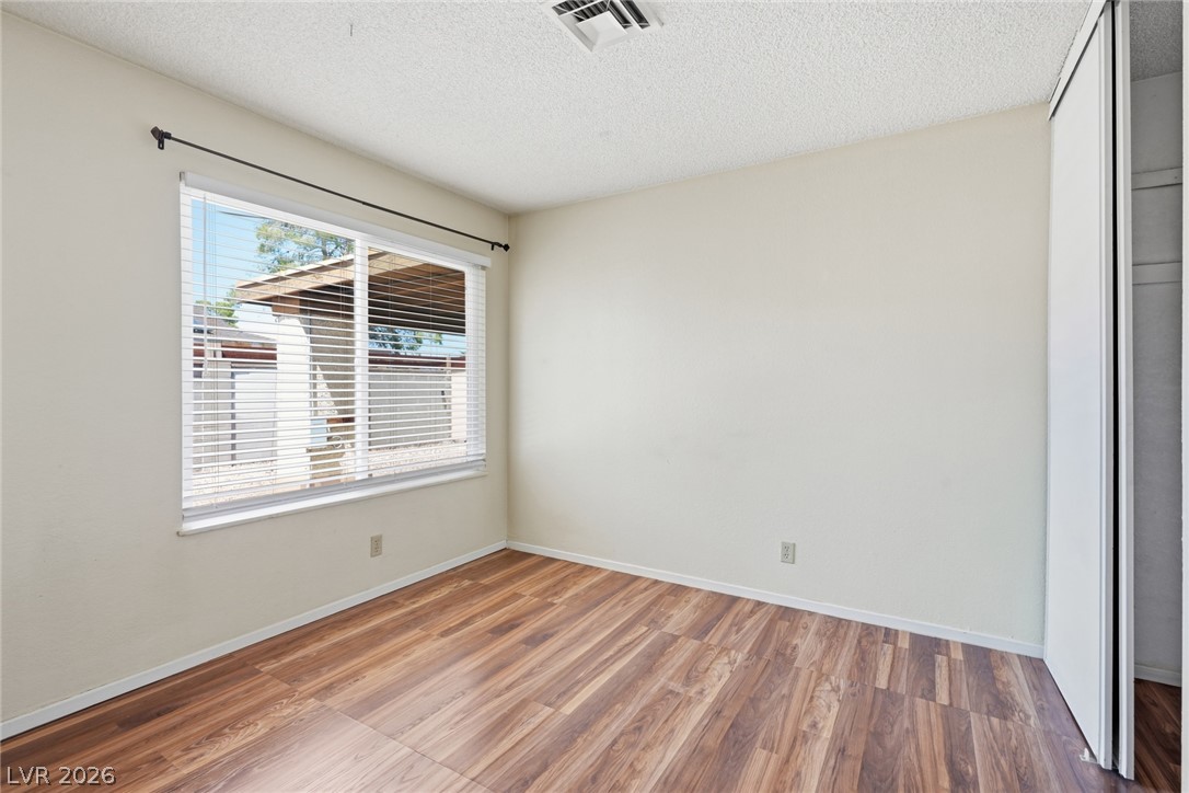 3971 Spring Leaf Drive Las Vegas, NV 89147 - Photo 32 of 48 A well-lit bedroom with rich wood flooring and a large window offering natural light.