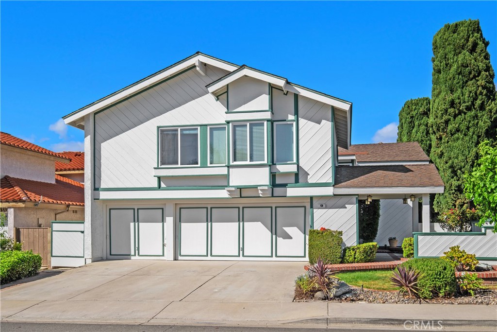 a front view of a house with a garden and plants