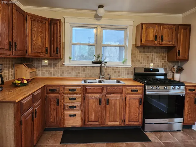 a kitchen with stainless steel appliances granite countertop a stove a sink and a microwave