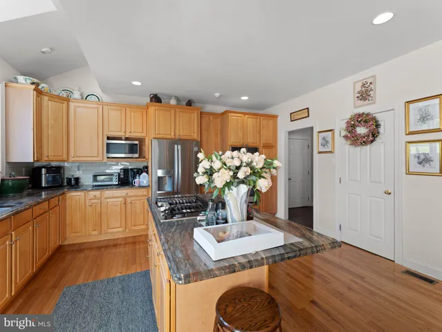 a kitchen with stainless steel appliances granite countertop a stove a sink and a refrigerator