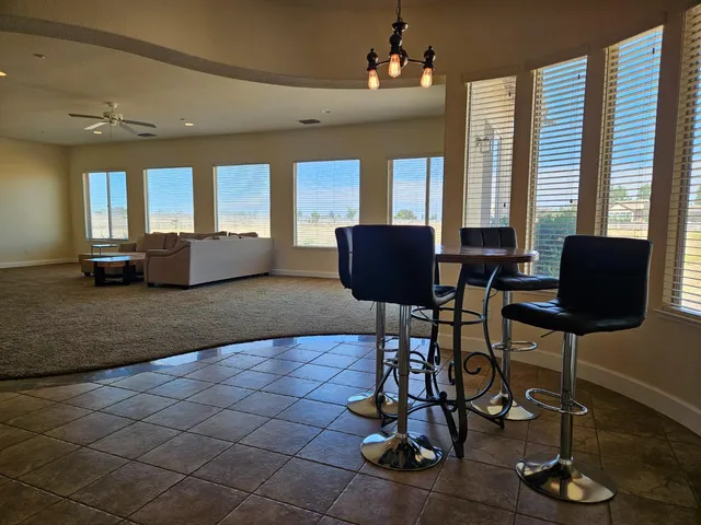 a living room with furniture a fireplace and large windows