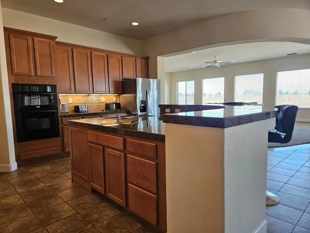 a kitchen with granite countertop a sink and a stove