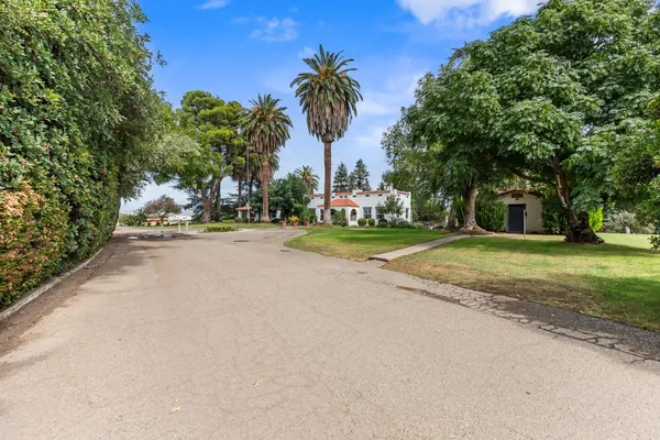 a view of a house with a yard and potted plants