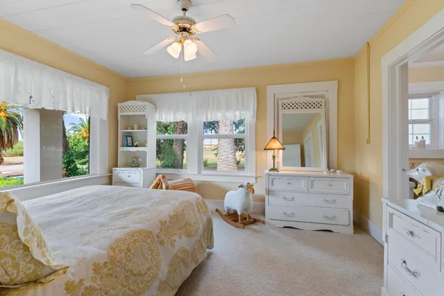 a bedroom with furniture and large windows