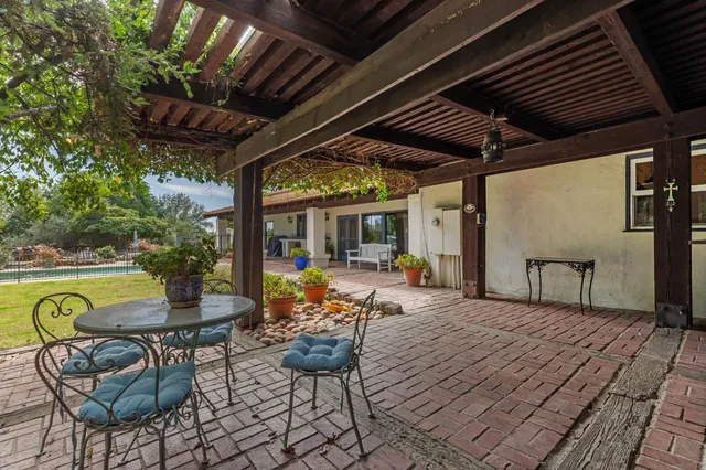 a front view of a building with a garden and trees