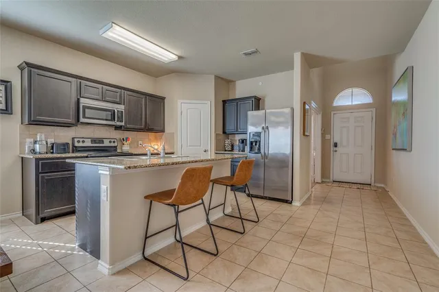 a kitchen with stainless steel appliances granite countertop a refrigerator and a stove top oven