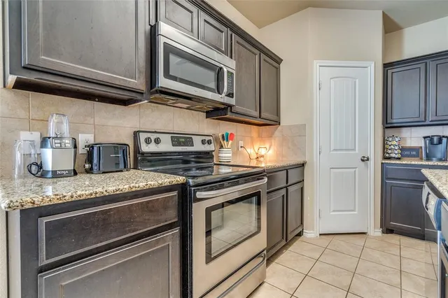 a kitchen with granite countertop cabinets stainless steel appliances and a sink