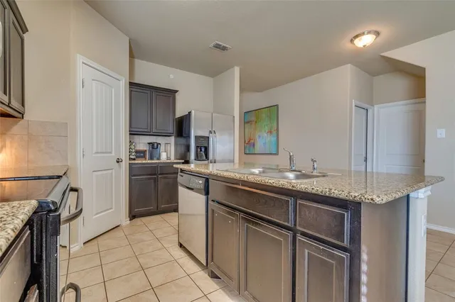 a kitchen with a sink appliances and cabinets