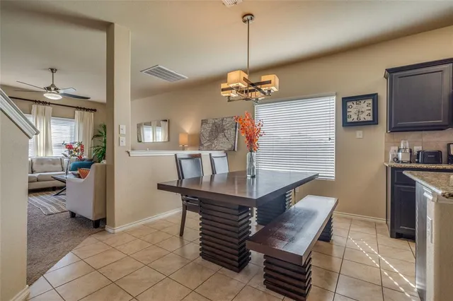 a view of a dining room and livingroom with furniture wooden floor a chandelier