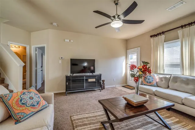 a living room with furniture a flat screen tv and a window