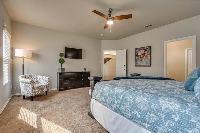 a spacious bedroom with a bed and a chandelier