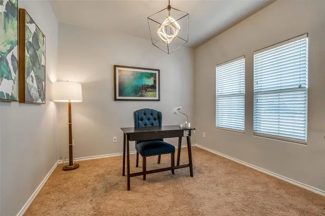 a view of a workspace with furniture and a window