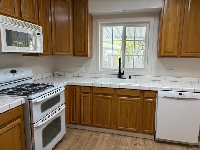 a kitchen with granite countertop cabinets stainless steel appliances and wooden floor