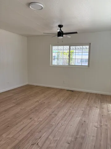 wooden floor in an empty room with a window