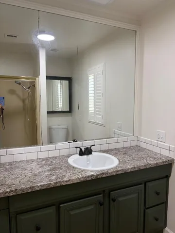 a bathroom with a granite countertop sink two mirror and a