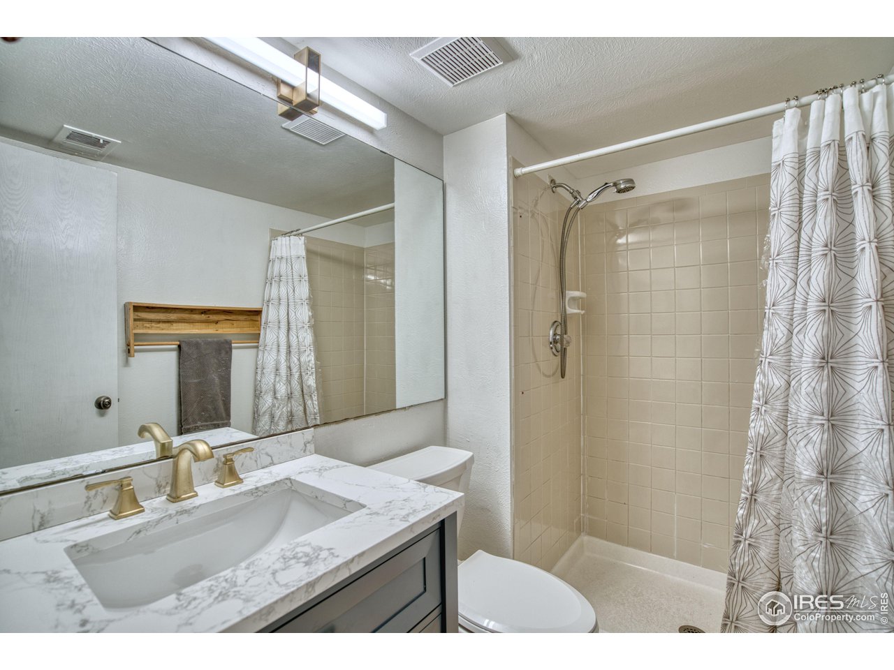 2154 Stuart Street Longmont, CO 80501 - Photo 11 of 27 a bathroom with a granite countertop sink mirror and shower