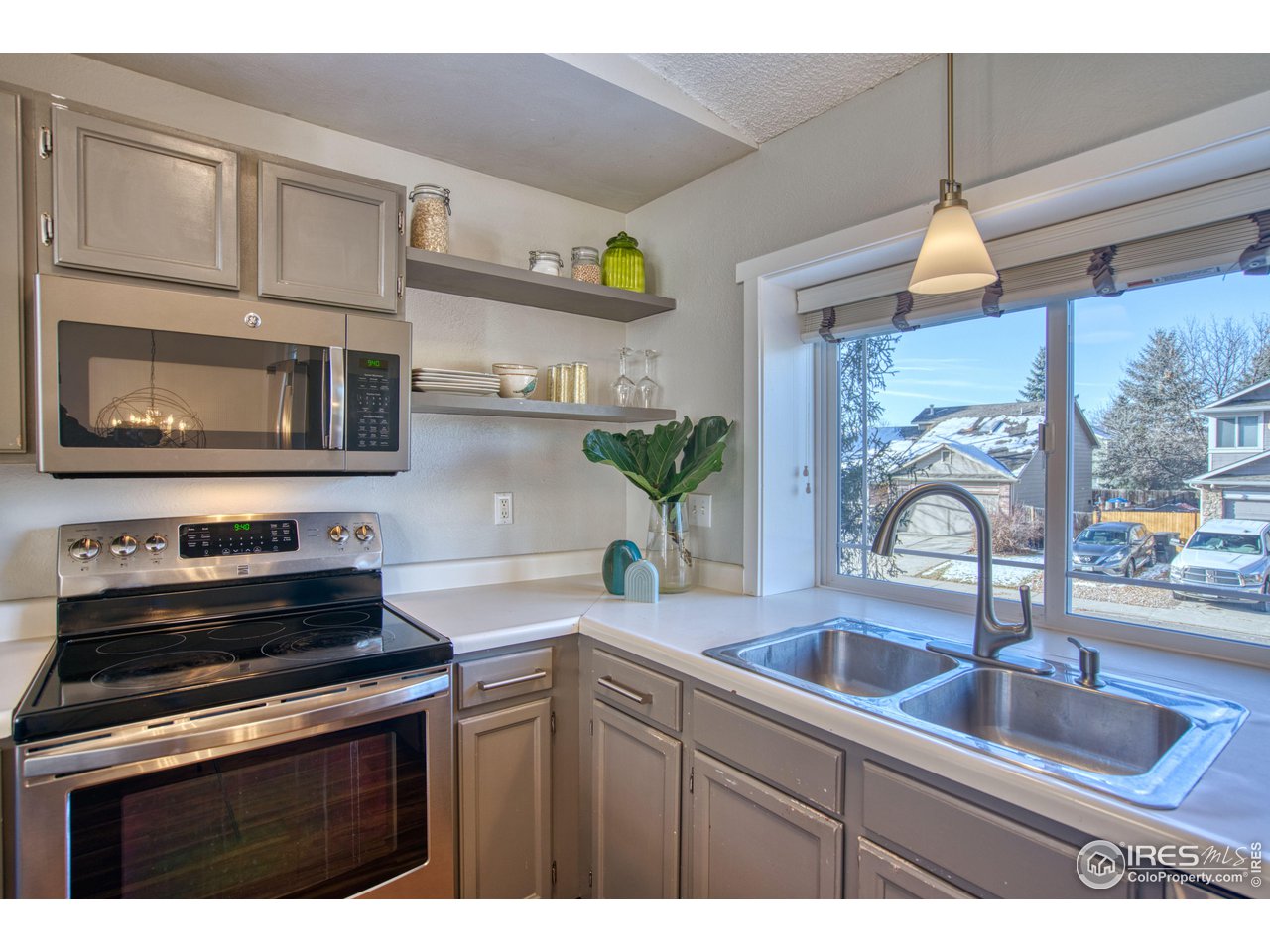 2154 Stuart Street Longmont, CO 80501 - Photo 18 of 27 a kitchen with kitchen island granite countertop a sink stainless steel appliances and cabinets