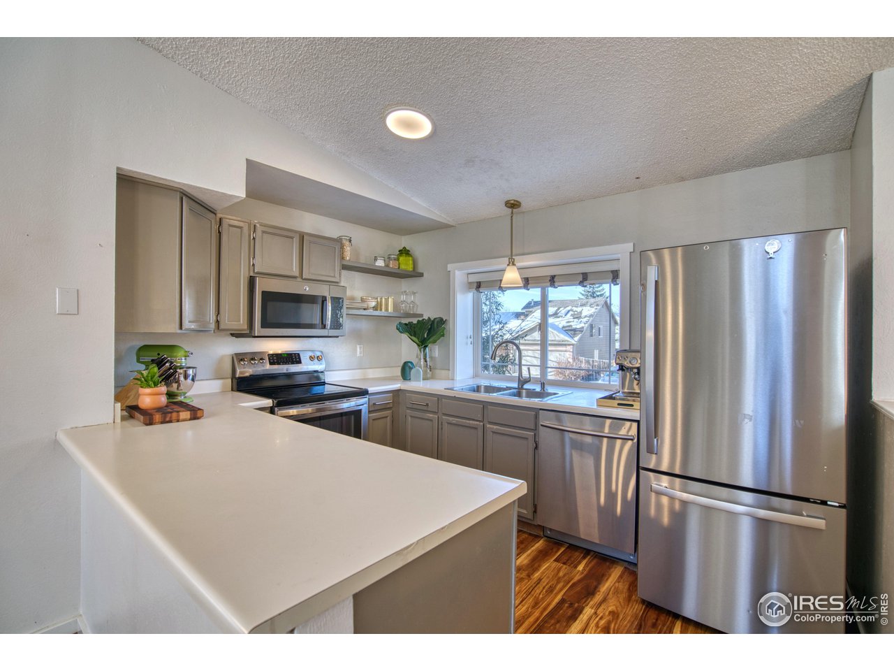 2154 Stuart Street Longmont, CO 80501 - Photo 21 of 27 a kitchen with stainless steel appliances a refrigerator sink stove microwave and cabinets