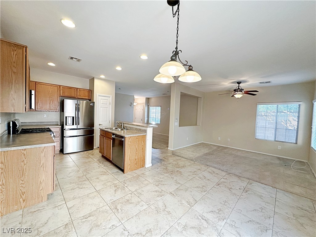 9620 Sharp Horn Court Las Vegas, NV 89149 - Photo 11 of 40 Kitchen with stainless steel appliances, decorative light fixtures, light countertops, a center island with sink, and recessed lighting
