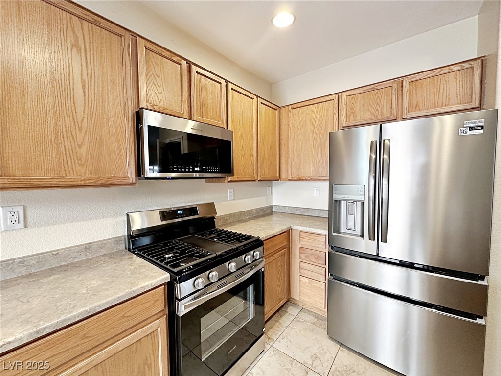 9620 Sharp Horn Court Las Vegas, NV 89149 - Photo 17 of 40 Kitchen featuring appliances with stainless steel finishes, light brown cabinets, light tile patterned flooring, and recessed lighting