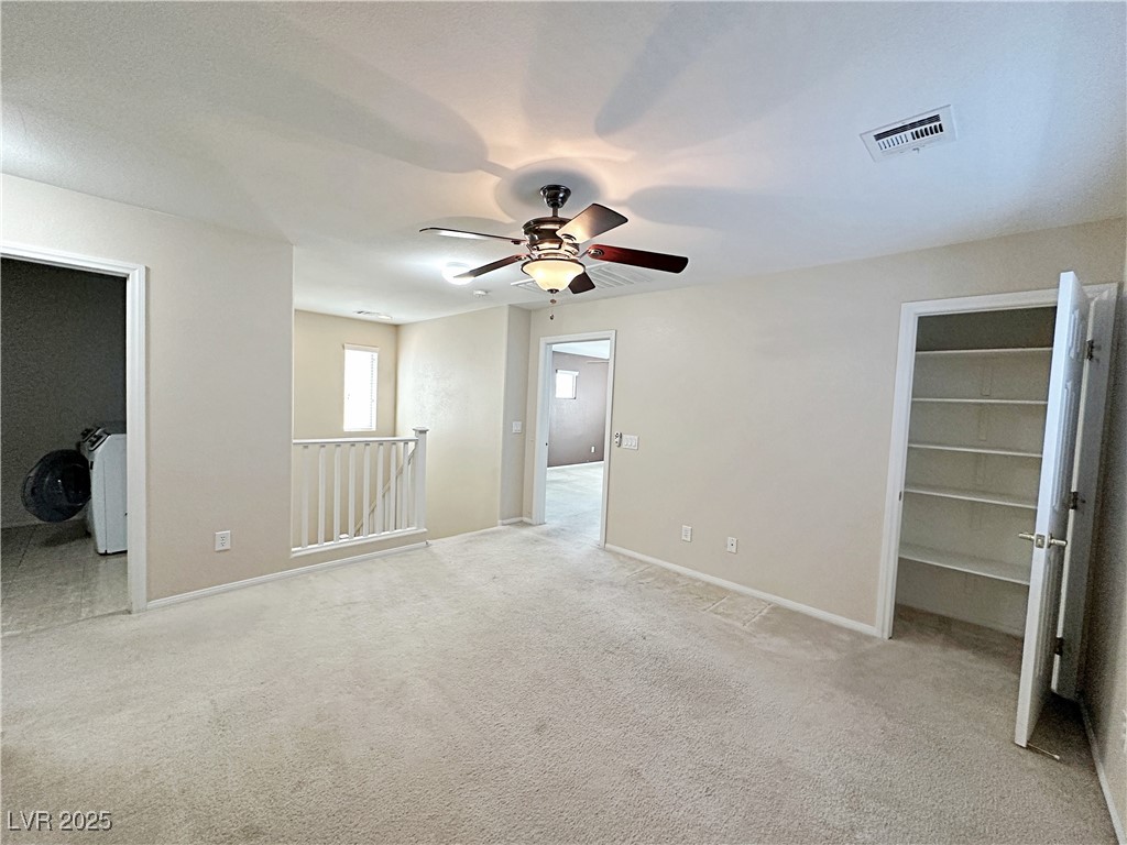 9620 Sharp Horn Court Las Vegas, NV 89149 - Photo 21 of 40 Unfurnished bedroom with light carpet, a ceiling fan, and a walk in closet