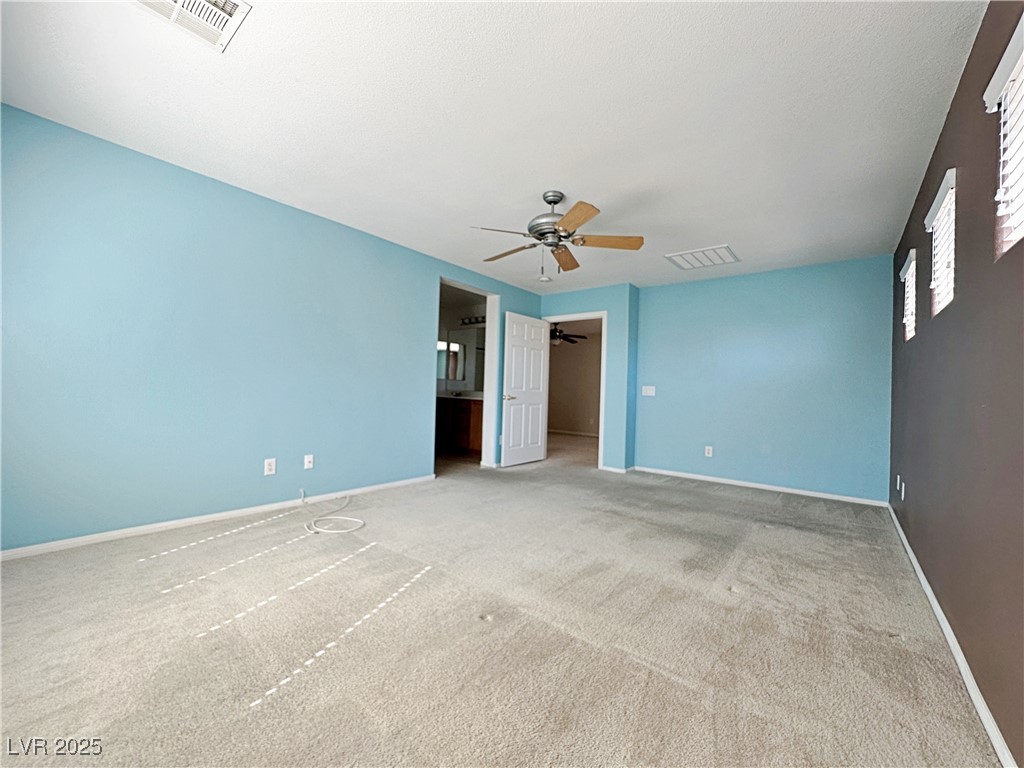 9620 Sharp Horn Court Las Vegas, NV 89149 - Photo 30 of 40 Unfurnished bedroom with carpet flooring, a walk in closet, ensuite bath, and a ceiling fan