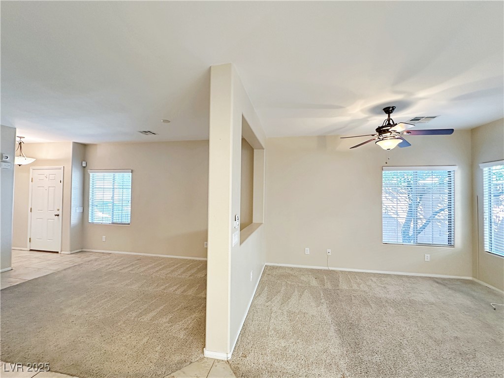 9620 Sharp Horn Court Las Vegas, NV 89149 - Photo 7 of 40 Spare room featuring light colored carpet, healthy amount of natural light, a ceiling fan, and light tile patterned floors