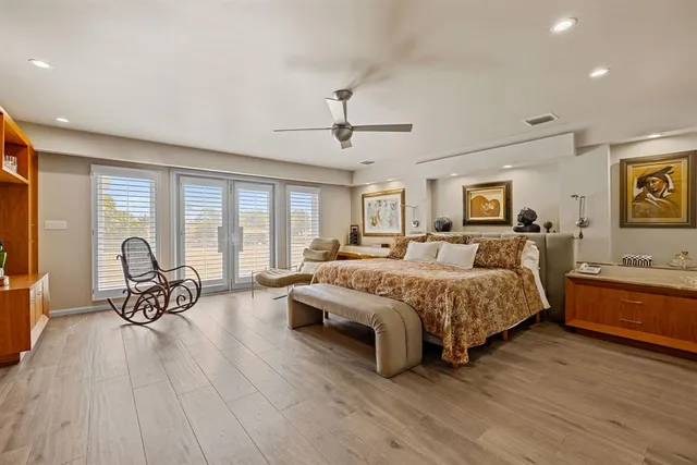 a spacious bedroom with a bed and wooden floor