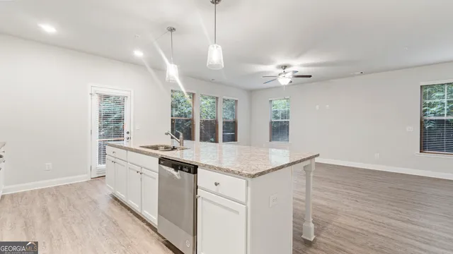 a kitchen with a sink stove and wooden floor
