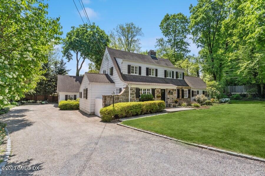 21 Stanwich Lane Greenwich, CT 06830 - Photo 2 of 45 a front view of a house with a garden and tree