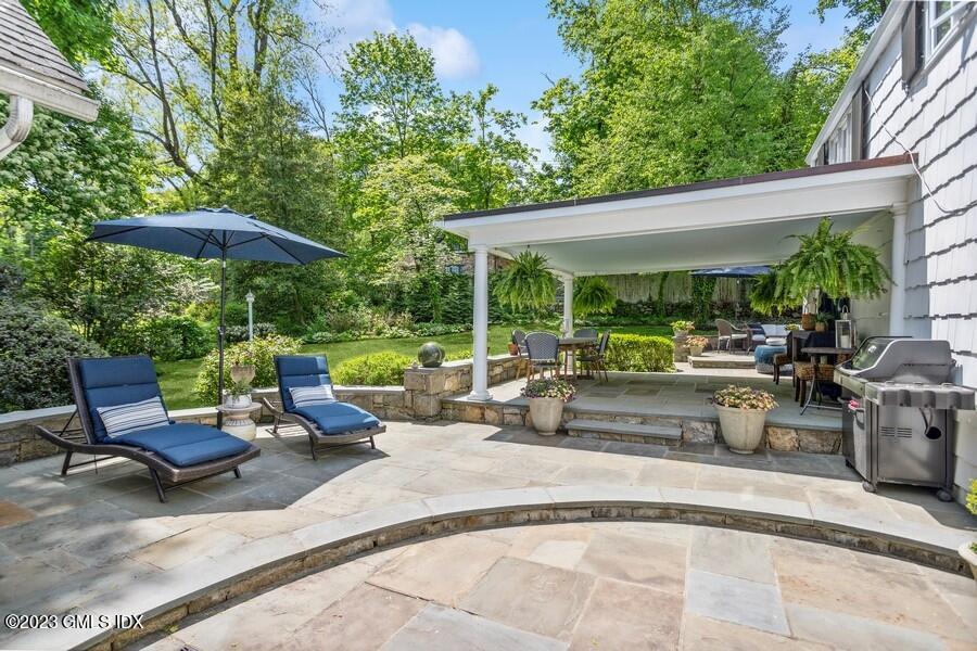 21 Stanwich Lane Greenwich, CT 06830 - Photo 28 of 45 a view of a patio with furniture and table under an umbrella