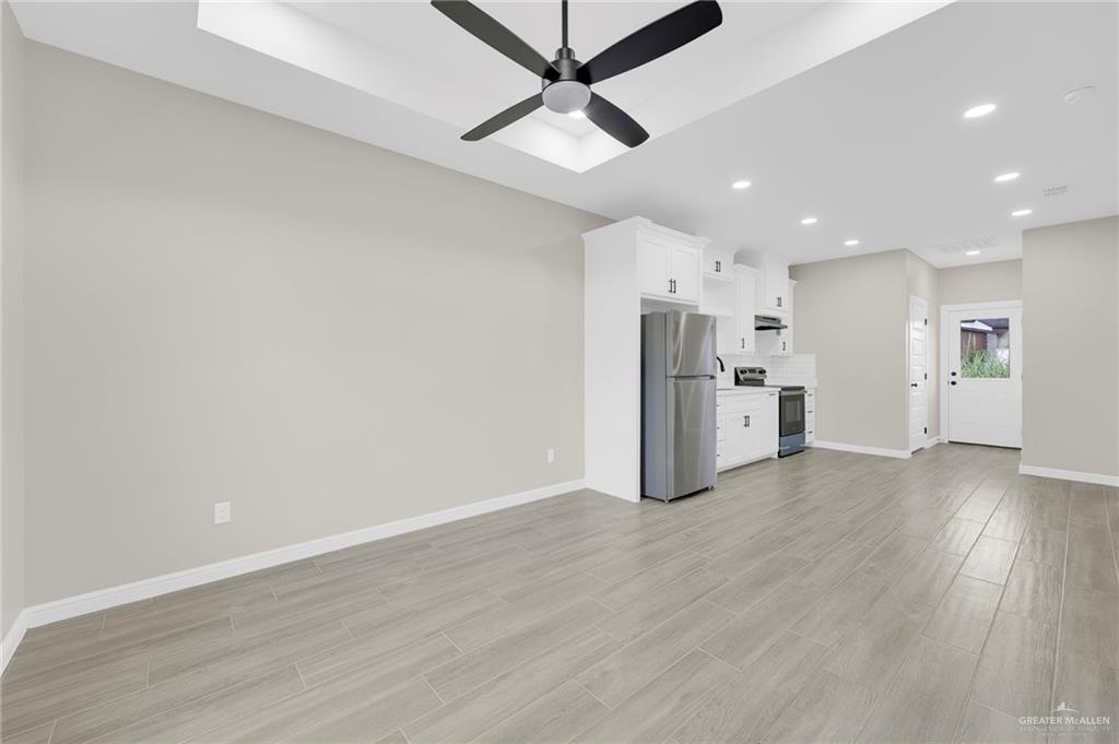 905 Crestview Street, Unit 2 Weslaco, TX 78596 - Photo 3 of 12 a view of a kitchen with a refrigerator a microwave and a ceiling fan