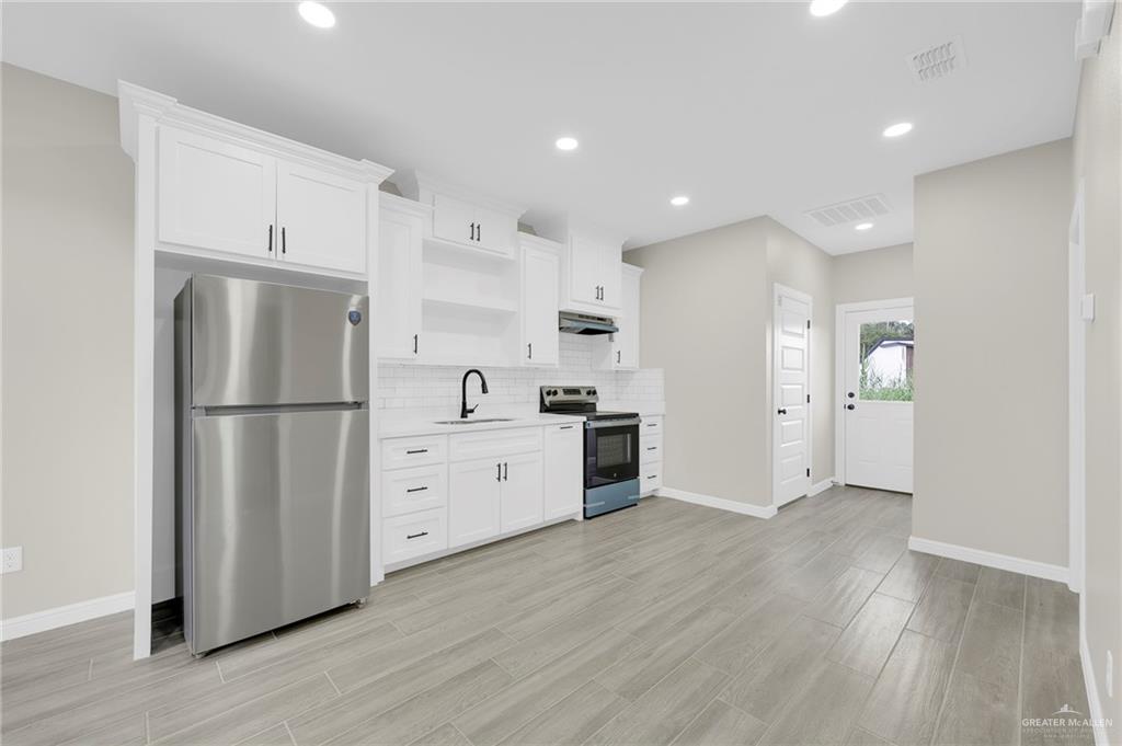 905 Crestview Street, Unit 2 Weslaco, TX 78596 - Photo 5 of 12 a kitchen with stainless steel appliances a refrigerator sink and cabinets