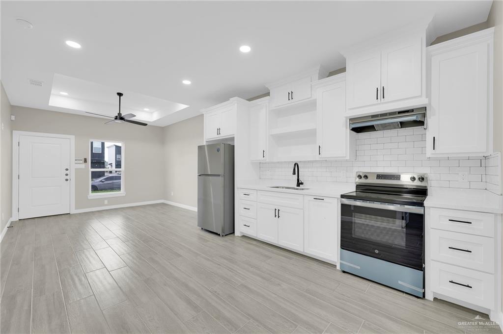 905 Crestview Street, Unit 2 Weslaco, TX 78596 - Photo 6 of 12 a kitchen with stainless steel appliances a stove a refrigerator sink and cabinets