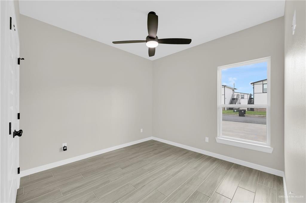 905 Crestview Street, Unit 2 Weslaco, TX 78596 - Photo 9 of 12 a view of a room with wooden floor and windows