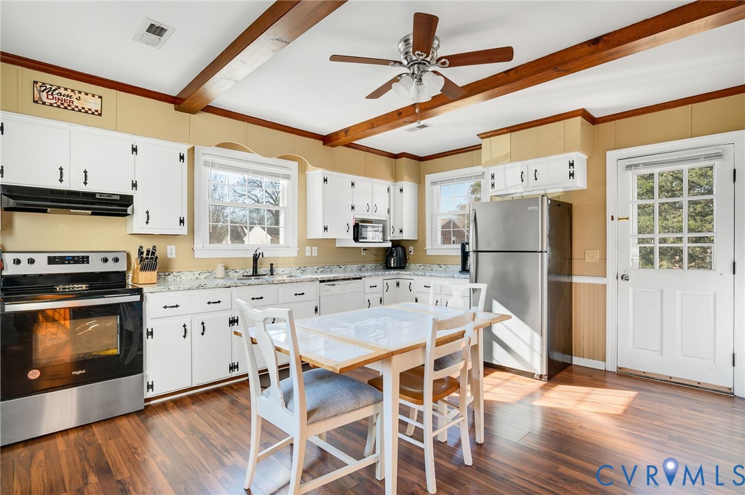 3203 Courthouse Road Hopewell, VA 23860 - Photo 7 of 23 a kitchen with stainless steel appliances granite countertop a stove a refrigerator a microwave oven with a dining table and wooden floor