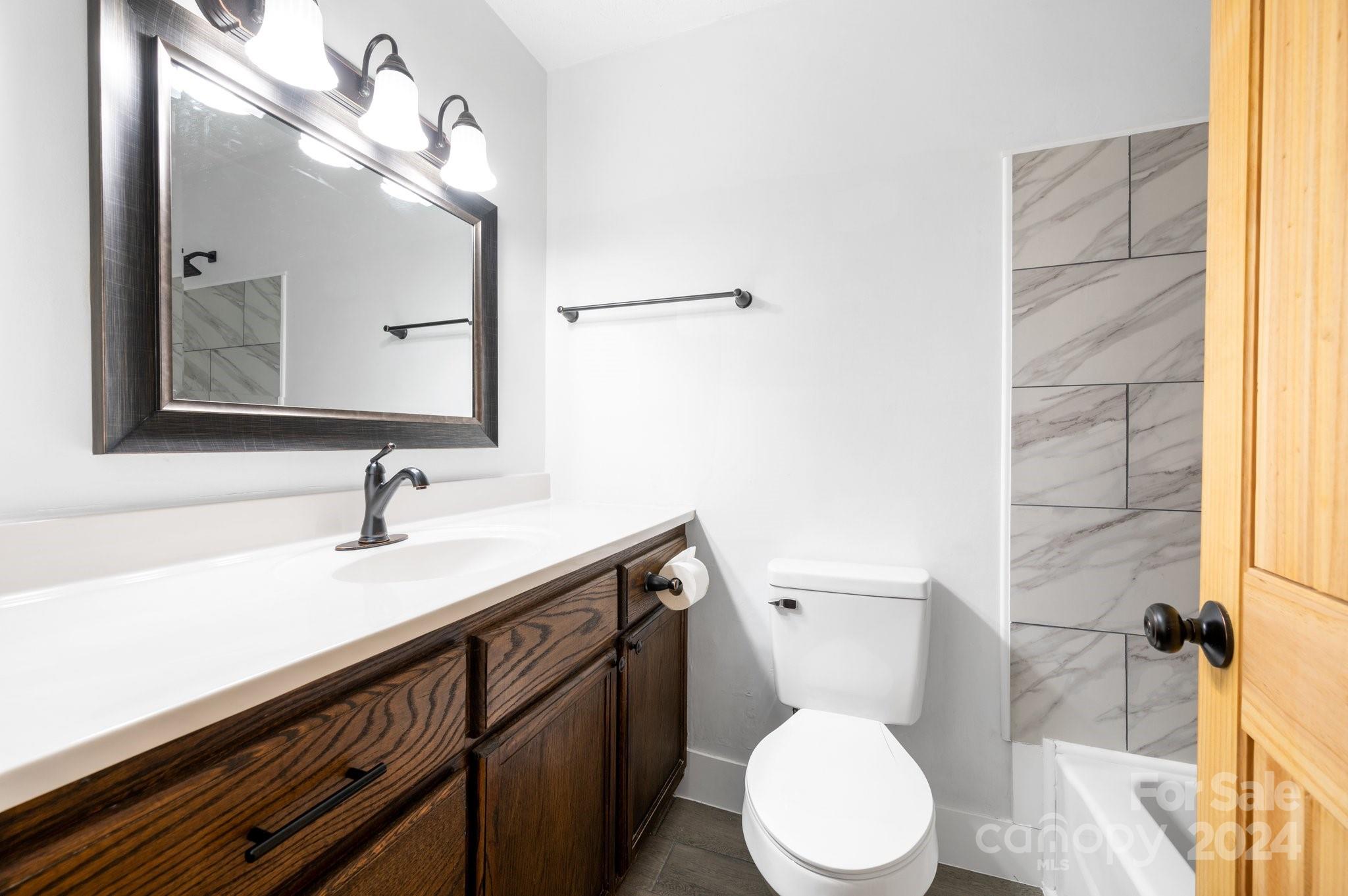 12 South Ridge Place Arden, NC 28704 - Photo 13 of 41 a bathroom with a granite countertop sink mirror and a toilet