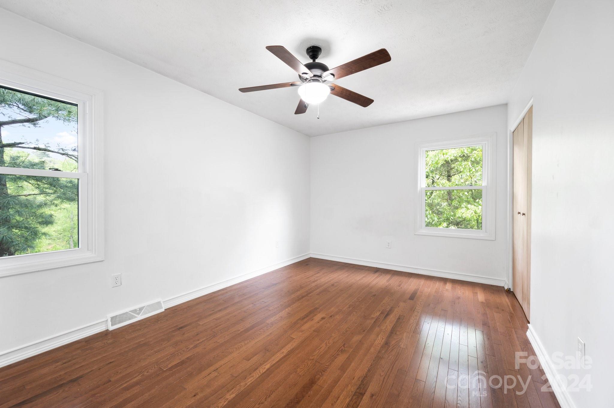 12 South Ridge Place Arden, NC 28704 - Photo 15 of 41 an empty room with wooden floor chandelier fan and windows